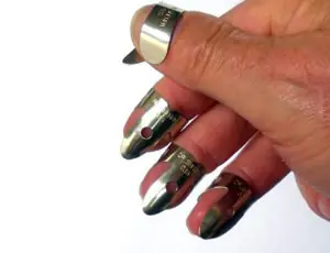 Close-up of finger and thumb picks worn on the fingertips for bluegrass-style guitar playing